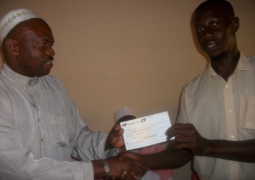 governor sanneh presenting cheque to dembo kambi