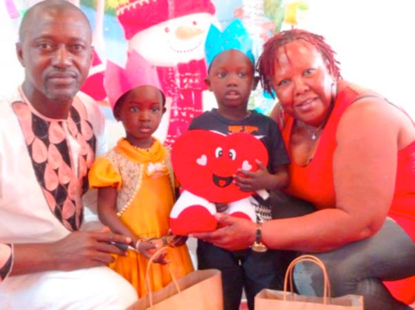 Charlotte Baurney and daughter present Christmas gifts to P.L. George Nursery School